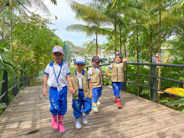 Estudiantes del colegio caminando sobre el puente, dirigiéndose a aprender en la reserva natural